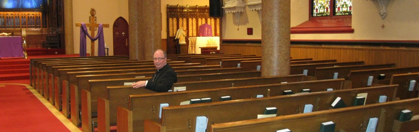 Bishop sitting in the pew at St. Peter-in-Chains Cathedral