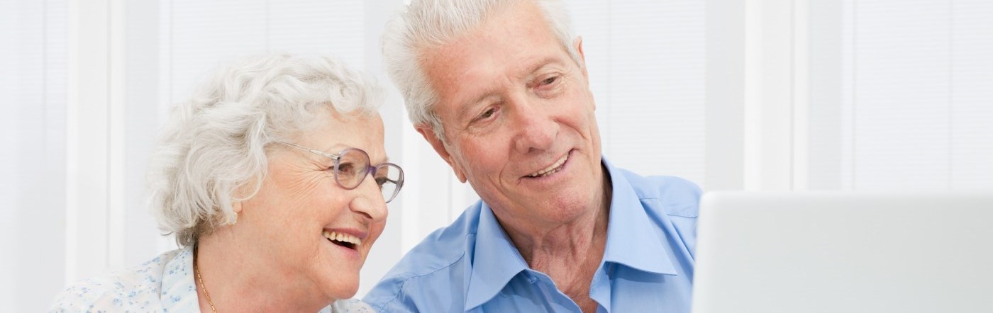Two aged people using a computer
