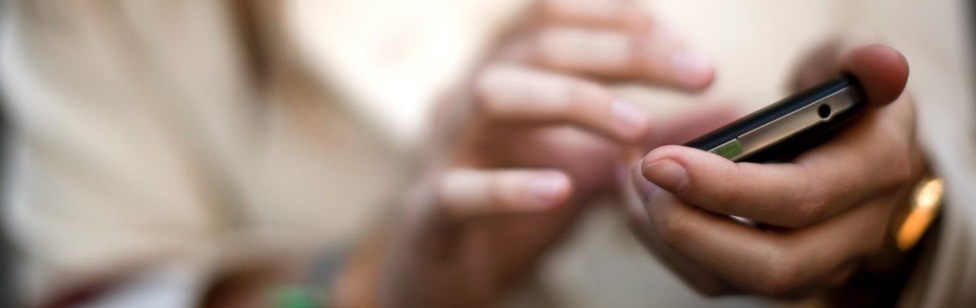 A person with a cellphone texting or calling