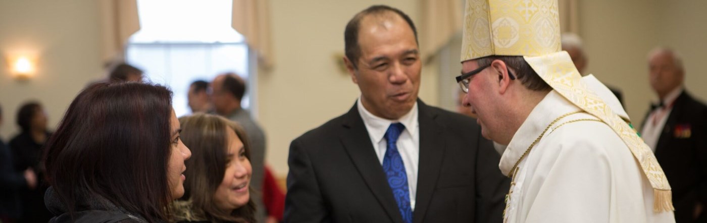 Bishop greeting a family