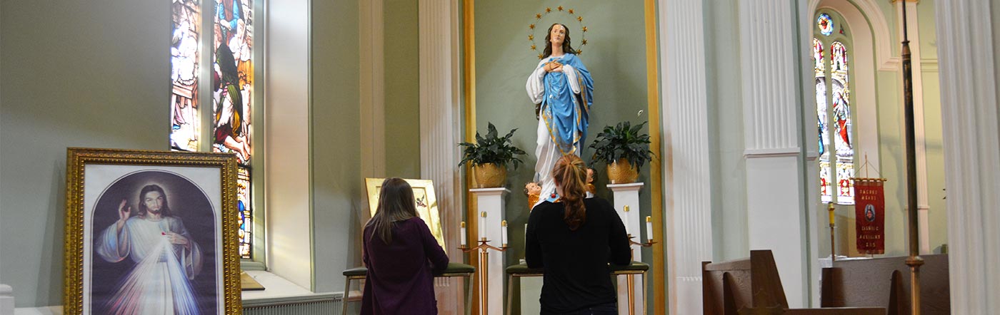 2 girls lighting candles in sanctuary